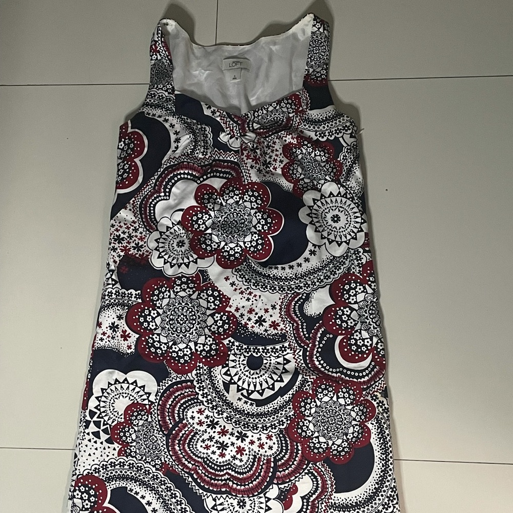 White dress with black and red detailed design.